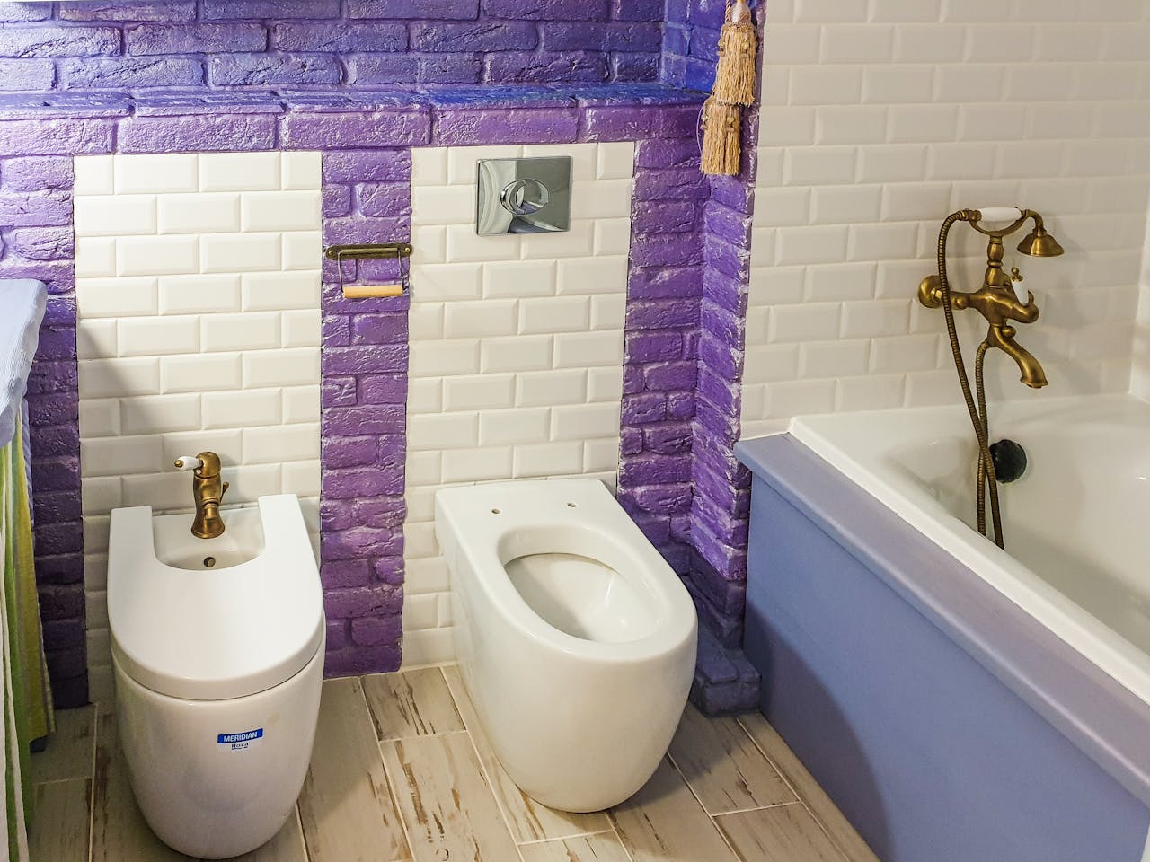 services-05 Stylish bathroom featuring a bidet and bathtub with vibrant purple and white tiles.